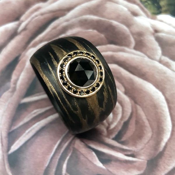 Aufregender breiter, konisch verlaufender Ring aus Carbon Bronze von Schwab mit einem großen schwarzen Diamanten im Rosenschliff, 1,5 ct umrandet von kleinen schwarzen Brillanten in 750/-Gelbgold gefasst. Designschmuck. Ringweite 55